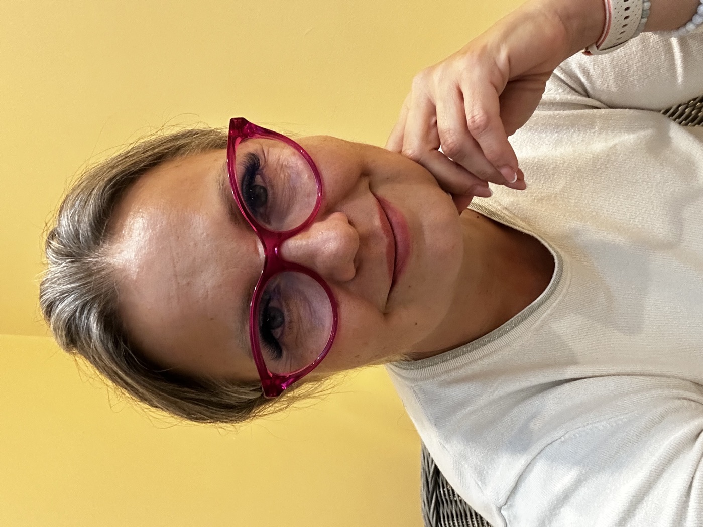 Aranyi Rita mosolyogva, állát a kezére támasztva figyel